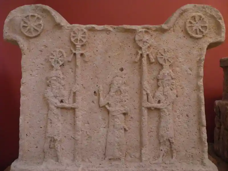 Solar discs on staffs held by men on an altar, offered by Tukulti-Ninurta I